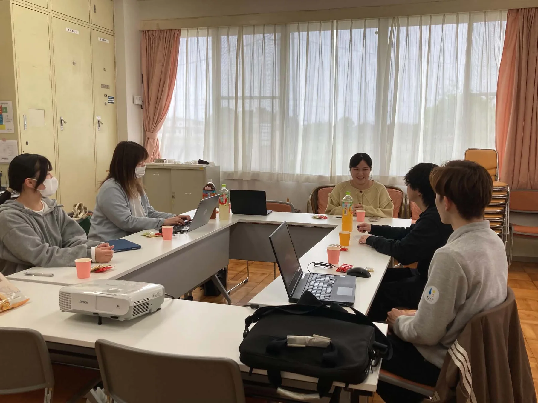 若者と企業側がテーブルを囲んで話し合っている様子