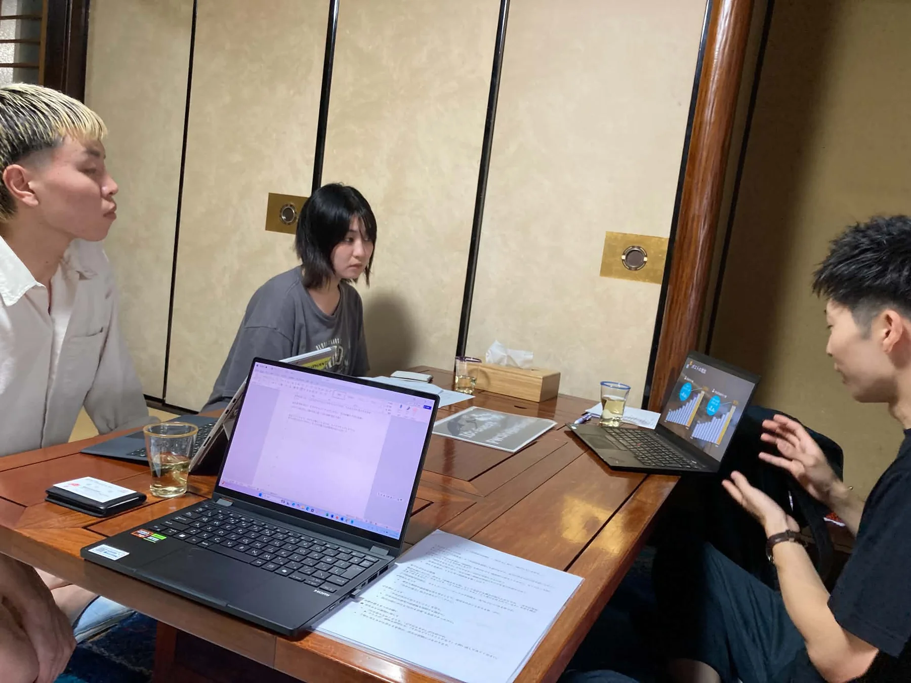 若者同士が資料を囲みながら話している様子